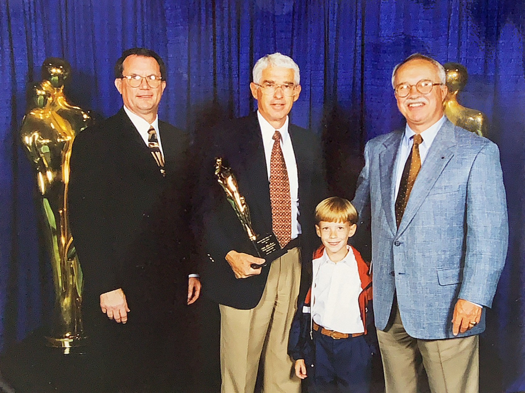 Harrison Bankston holding an award with team